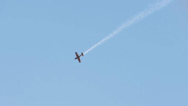 Airplane with a trace of smoke on the WWII historical military reconstruction battle.