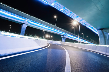 Empty road floor with city viaduct bridge of neon lights night