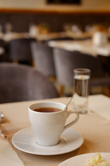 white cup with tea on the table. close-up.