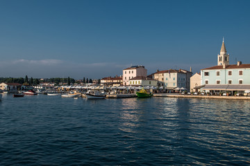 Fototapeta na wymiar Picturesque Village Fazana In Croatia With Old Church And Boats In Harbor