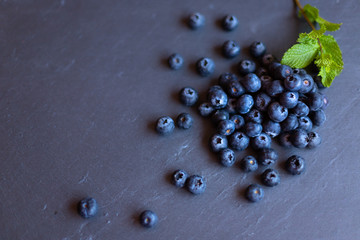 Aerial image of blueberries on blackboard with a mint branch