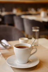 white cup with tea on the table. close-up.