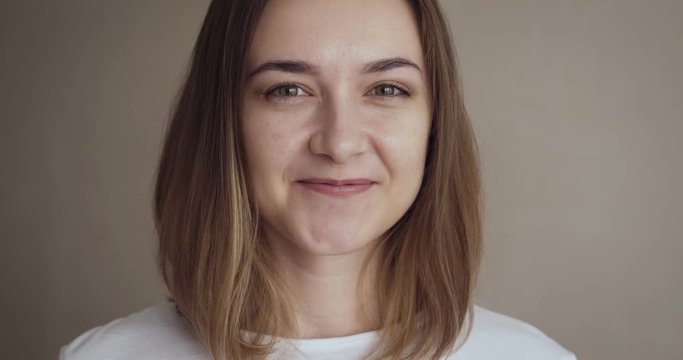 Portrait of young woman smiling and laughs on camera.
