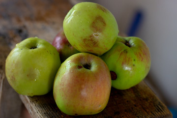Red apples in a wooden plate on dark background. Green apples on a dark background. Green apple