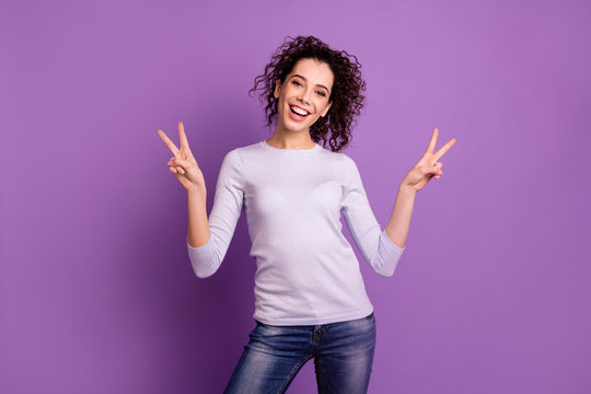 Photo of amazing lady with beaming toothy smile holding hands in v-sign symbols excited positive mood wear pullover isolated purple color background