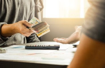 Two businessmen give and take US dollar banknote  .US dollar is main and popular currency of...