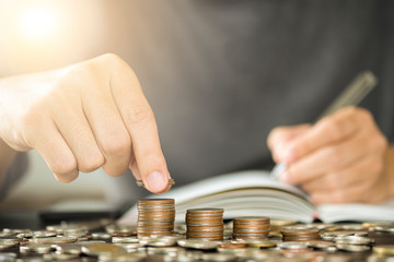 Man hand putting coins stacking for growth business and saving investment concept.