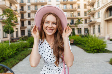 Optimistic young redhead woman walking outdoors