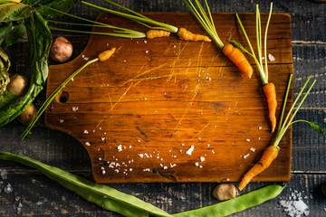 wooden table with baby carrots in circle for titles. background. Top view. Free copy space.