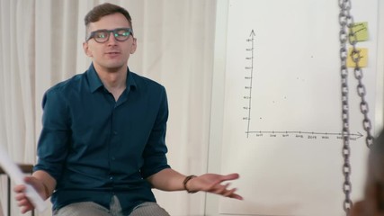 Business Man Team Leader or Trainer is Disscussing Project with Employees in Loft Office. Seminar or Pesentation in Diverse Group of People. Meeting at Work. 4K Medium Gimbal Orbit Shot