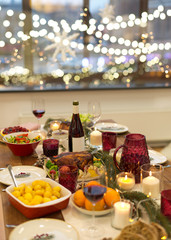 christmas dinner and eating concept - food and drinks on table at home