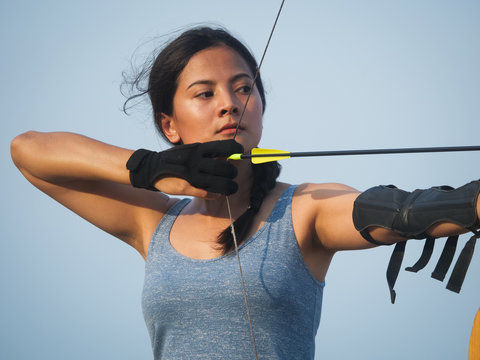 Asian Archery Woman With Bow Shooting On The Beach