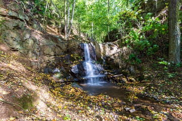Autumn nature Waterfall (D&iacute;rka) in Czech forest landscape, rocky mountains. Side view 2