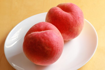 Ripe peaches on white plate