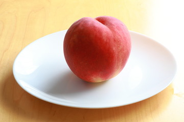 Ripe peach on white plate
