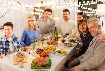 celebration, holidays and people concept - happy family having dinner party at home