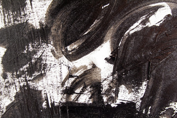 Closeup black acrylic brush strokes and scribble on white canvas. Abstract grunge handmade drawing.