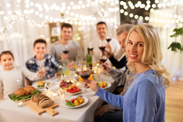 celebration, holidays and people concept - happy family having dinner party, drinking red wine and toasting at home