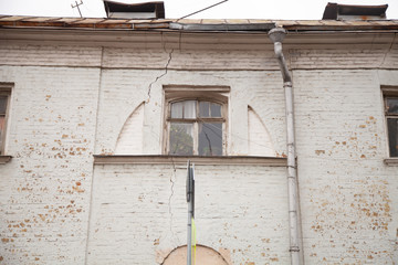 cracked brick white wall with old window with nobody