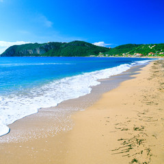 Beautiful summertime panoramic seascape. Awesome view picturesque green slopes coastline sea and golden sand beach shore in the crystal clear azure water sea bay. Afionas. Corfu. Greece.