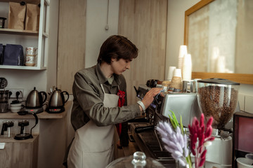 Good-looking man working with professional coffee machine