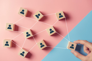 Building a strong team, Wooden blocks with people icon on blue and pink background, Human resources...