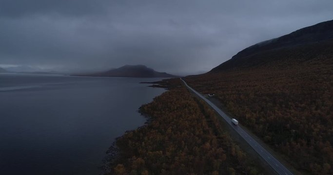 Truck on a arctic road, Aerial, descending, drone shot, revealing a lorry on e8 route, on a moody and rainy, autumn evening, in Enontekio, Kilpisjarvi, Suomi