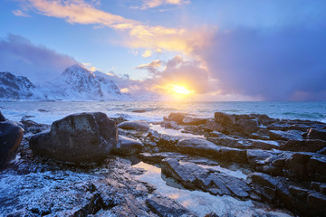 Fototapeta premium Coast of Norwegian sea on rocky coast in fjord on sunset