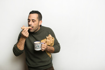 Uomo assapora un biscotto u sfondo bianco