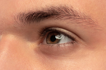 Fototapeta na wymiar Caucasian young man's close up portrait. Beautiful male model with well-kept skin. Concept of human emotions, facial expression, sales, ad. Brown eye looking at side and eyebrow.