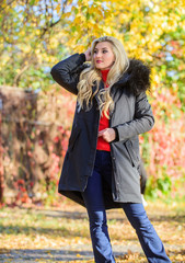 Fototapeta na wymiar Woman long blonde hair wear stylish outfit with parka. Create fall outfit to feel comfortable and pretty. Modern outfit for youth. Girl in warm coat stand in park nature background defocused