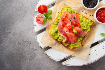 Toast with avocado, red fish (salmon, trout), caviar and black sesame. Tasty, bright, delicious healthy breakfast or lunch