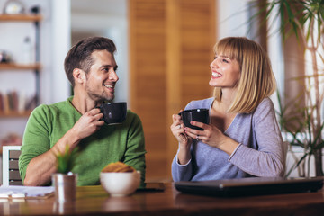 Couple talking in the night in the living room at home and drink tea