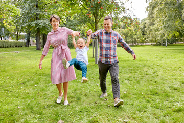 Obraz premium family, leisure and people concept - happy mother, father and little son having fun at summer park