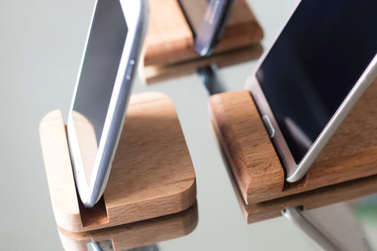 wooden stands for smartphones on the mirror surface, environmental stands for fixing smartphones. professional photo