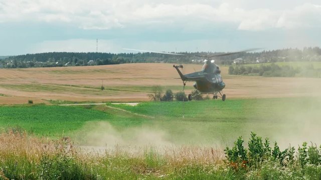 The helicopter is seen in the middle of a field on a summer sunny day