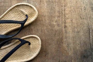 Vintage cosy sandal or slipper is placed on the wooden surface with copy space. Concept photo to...