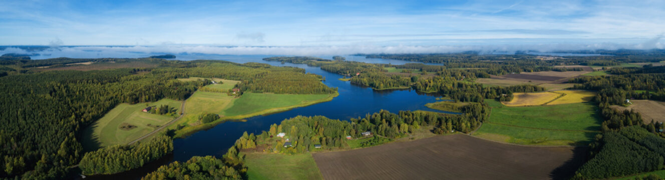 Beautiful countryside landscape with fields, river, forest and huge lake. Aerial panorama of Finland on autumn.