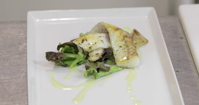Pesce fresco in un piatto con insalata, pronta per essere servito come secondo in un ristorante