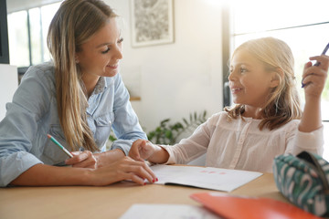 Obraz premium Mother helping daughter with homework