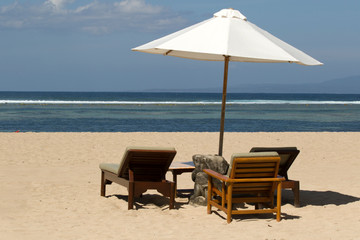 Parasol with chairs on the tropical beach of Sanur on Bali