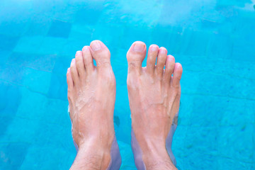 man feet in swimming pool