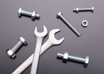 Wrenches and bolts on a dark background. Industrial still life of the tool. Fastening tool top view. Bolts and nuts. 