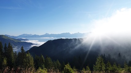 beautiful view over the mountains to the alps in the morning with fog in the valley