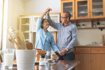 Senior couple elderly dancing together have fun and happiness. Old man and old women enjoy together morning in home.