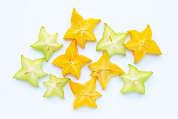 Green and yellow sliced ripe star fruit on white