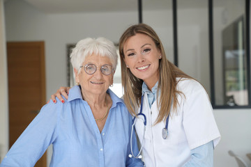 Portrait of elderly woman with nurse a thome