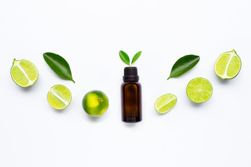 Essential oil with Limes and leaves isolated on white