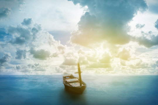 old boat floating on the sea with cloudy sky