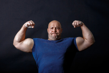 A portrait of bald strongman in dark t-shirt